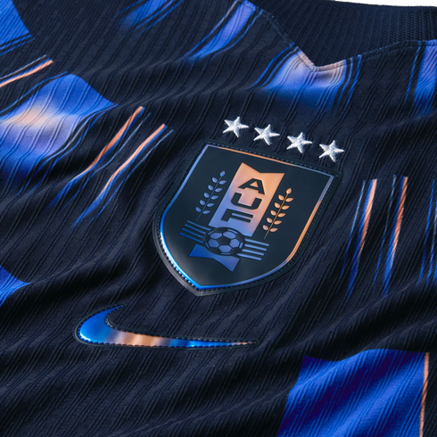 Close-up of a dark blue textured Uruguay soccer jersey featuring the AUF crest with four stars and a metallic Nike swoosh.