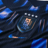 Close-up of a dark blue textured Uruguay soccer jersey featuring the AUF crest with four stars and a metallic Nike swoosh.