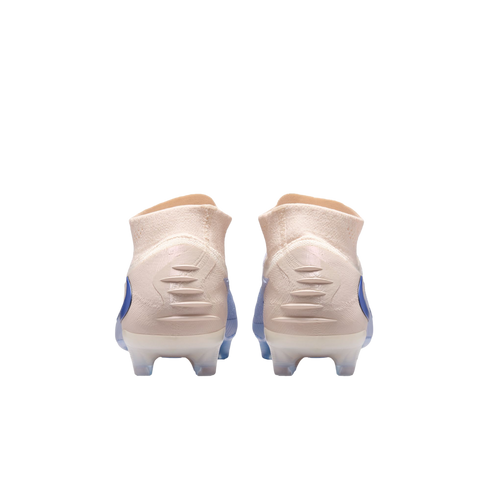 Rear view of peach-colored soccer cleats with blue accents and white translucent studs, set against a solid black background.