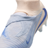 Close-up of a light blue and peach Nike soccer cleat with a textured, laceless knit upper and a sock-like collar against a black background.
