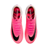 Top-down view of bright pink Nike soccer cleats on a white background. Each shoe features a large black swoosh, pink laces, and "ZOOMX" printed on the inner sole.