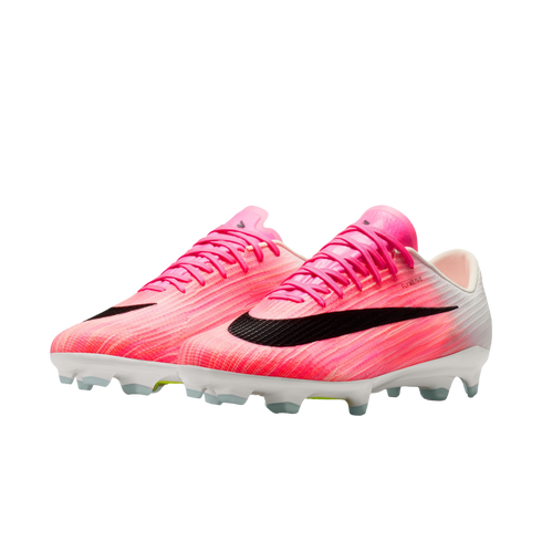 Bright pink and white Nike soccer cleats with large black swooshes and white studded soles, isolated on a white background.