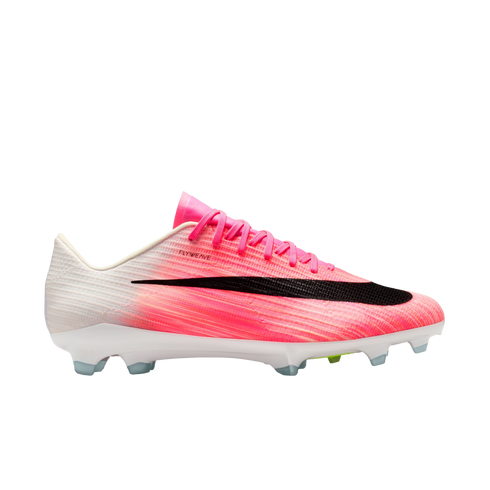 Profile view of a pink and white Nike Flyweave soccer cleat featuring a large black swoosh and clear-tipped studs on a white background.