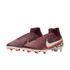 A pair of maroon Nike soccer cleats with a knitted texture and high-top collar, featuring a white swoosh and a bold animal print pattern on the heel, set against a solid black background.
