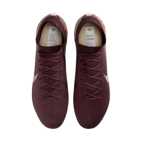 A top-down view of a pair of maroon Nike soccer cleats with a textured pattern and matching laces, set against a black background.