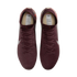 A top-down view of a pair of maroon Nike soccer cleats with a textured pattern and matching laces, set against a black background.