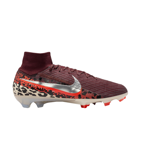 A high-top Nike soccer cleat is shown from a side profile against a solid black background. The shoe features a burgundy ribbed upper and a matching sock-like ankle collar. A large, metallic silver Nike swoosh with an orange border sits on the side, print