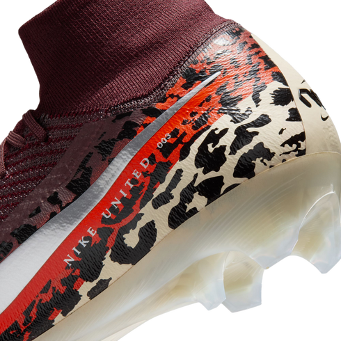 A close-up, angled view of the heel and ankle area of a Nike soccer cleat against a black background. The shoe features a burgundy ribbed knit ankle collar and a main body decorated with a bold leopard-print pattern in cream, black, and vibrant orange. A