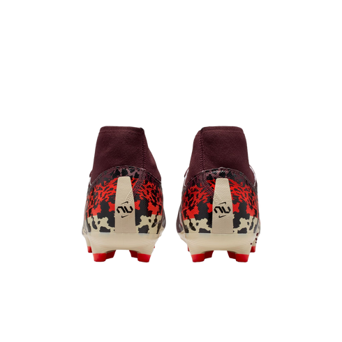 A rear view of a pair of maroon soccer cleats with a red, black, and cream graphic pattern on the heels. The boots feature a stylized logo on the back and red studs on a cream-colored sole, all set against a solid black background.