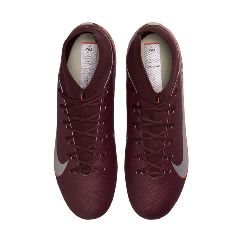 A top-down view of a pair of deep maroon Nike soccer cleats with silver swooshes and high-top ankle collars, set against a solid black background.