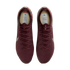 A top-down view of a pair of maroon Nike soccer cleats with a textured, knitted upper against a solid black background.