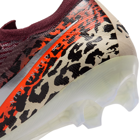 A close-up view of the heel of a Nike soccer cleat featuring a vibrant leopard print in black, orange, and beige. The text "NIKE UNITED 003" is visible along a silver stripe, and the shoe has a translucent white soleplate with clear studs.