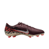 A side profile of a Nike soccer cleat against a solid black background. The shoe features a dark maroon textured upper, a silver Nike swoosh with a red outline, and a tan soleplate with bright red studs. A graphic pattern in red, black, and tan covers the