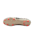 An underside view of a cream-colored soccer cleat featuring bright neon orange studs, showing a black and white abstract graphic pattern along the edges against a solid black background.