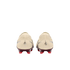 A rear view of a pair of cream-colored soccer cleats with maroon heel plates and bright red studs, set against a solid black background.