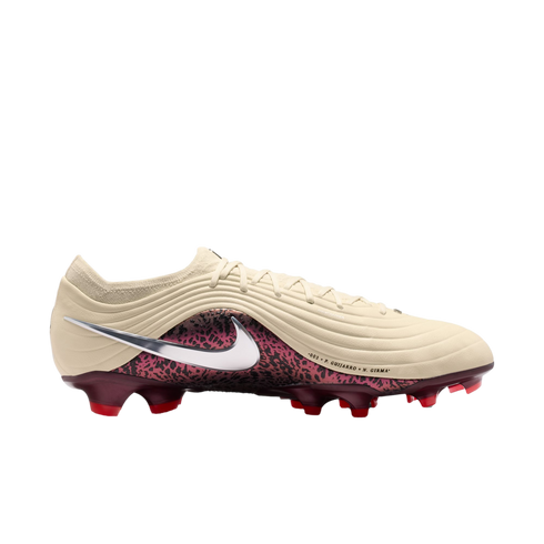 A profile view of a Nike soccer cleat against a solid black background. The upper part of the boot is a textured, off-white cream color with wavy lines. A large metallic silver swoosh is prominently displayed on the side, overlapping a burgundy section wi