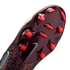 A close-up view of the glossy burgundy outsole of a Nike soccer cleat, featuring bright red studs and a grey swoosh logo. The textured upper of the shoe shows a dark, bronze-colored animal-print pattern.
