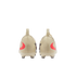 The rear view of two cream-colored soccer cleats with red swooshes on the heels and a black background.
