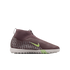 Side view of a mauve Nike soccer turf shoe with light green accents and a white speckled sole, isolated on a black background.