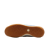 A view of the gum rubber outsole of a shoe against a black background, featuring an intricate herringbone tread pattern and a white hexagonal Nike logo in the center.