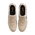 A top-down view of a pair of cream-colored Nike Tiempo Ligera soccer shoes with gold accents against a black background.