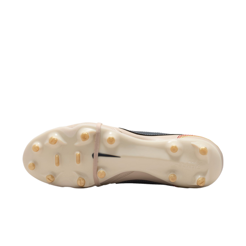Underside of a cream-colored Nike Tiempo soccer cleat with gold studs, featuring a black swoosh in the center and embossed branding on the heel.