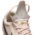 A close-up of a beige leather athletic shoe with its tongue flipped up. The word "Ligera" is embroidered in gold script above beige laces.