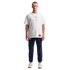 A man stands against a black background wearing a white Nike U.S.A. t-shirt, navy blue USA sweatpants, and white sneakers.