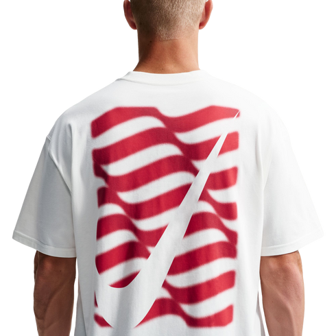 Rear view of a person in a white t-shirt with a red wavy striped graphic and a large white Nike swoosh on the back.