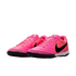 Bright pink Nike turf soccer shoes with a black swoosh and black soles on a white background.