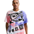 A man with short hair and a mustache stands against a solid black background, wearing a white t-shirt with a large, colorful Nike graphic. The graphic includes a central globe design with a black swoosh, surrounded by arrows and spray-paint style patterns