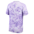 Back view of a short-sleeved athletic shirt with a large-scale lavender tonal floral print and subtle lime green trim along the shoulder seams.
