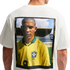 The back of a white t-shirt featuring a large, rectangular graphic print of Brazilian soccer legend Ronaldo Nazário. He is wearing a yellow Brazil national team jersey, and the portrait is enclosed in a black frame with yellow Nike branding text.