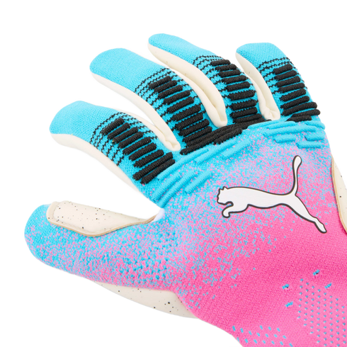 A close-up shot of a Puma goalkeeper glove featuring a vibrant pink and blue gradient design with black textured grip accents on the fingers and a white Puma logo.