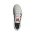 Top-down view of a light grey suede Adidas shoe with dark green and red stripes and white laces, centered on a black background.