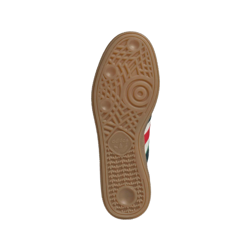 Textured tan gum rubber outsole of an Adidas sneaker featuring an intricate tread pattern and logo.