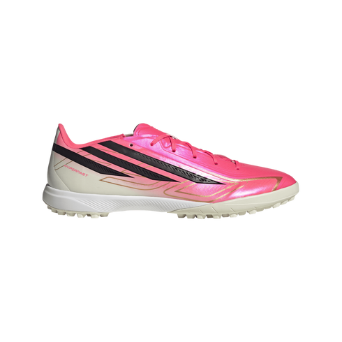 Vibrant pink and white athletic turf shoe with three bold black diagonal stripes, gold detailing, and "HYPERFAST" text on the side.