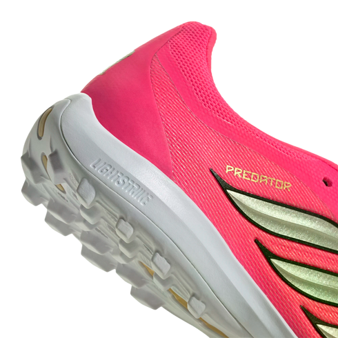 Close-up of a pink Adidas Predator shoe heel with a white Lightstrike midsole and textured outsole.
