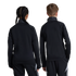 Back view of two children, a girl with braided hair and a boy, wearing matching black athletic tracksuits against a white background.