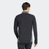 Back view of a man wearing a black long-sleeved athletic top with grey side panels and collar, paired with black pants.