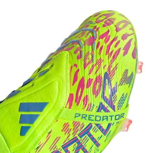 Close-up of a lime green Adidas Predator soccer cleat featuring vibrant pink and blue patterns and a midfoot strap.