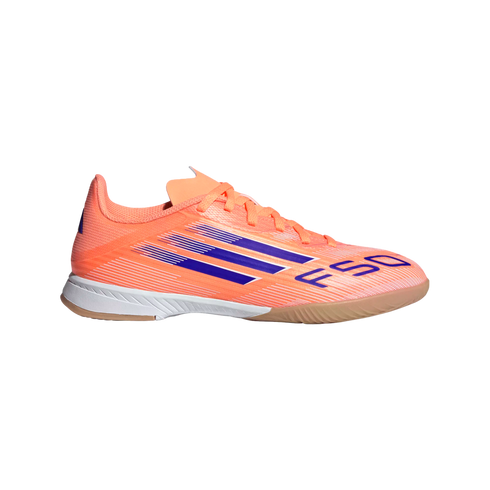 Profile view of a bright orange Adidas F50 indoor soccer shoe with purple stripes and a white and gum outsole, against a black background.