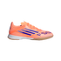 Profile view of a bright orange Adidas F50 indoor soccer shoe with purple stripes and a white and gum outsole, against a black background.