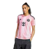 Woman wearing a pink striped Inter Miami CF soccer jersey and dark cargo pants against a white background.