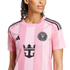 A woman wearing a pink Inter Miami CF soccer jersey featuring the team crest, Adidas logo, and Royal Caribbean sponsorship logo on the front.