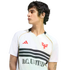 A man in a white D.C. United jersey with black stripes and red logos, looking away in profile against a black background.