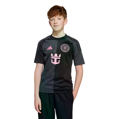 A young boy with reddish hair wearing a black and charcoal Inter Miami soccer jersey.