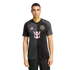 A man models a two-toned grey and black Inter Miami CF soccer jersey featuring pink logos on a plain white background.