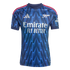 Blue Arsenal football jersey with a jagged lightning pattern, white "Emirates FLY BETTER" sponsor, silver cannon crest, and red shoulder stripes.
