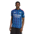 Man modeling a blue Arsenal football jersey with a zigzag pattern and white Emirates logo on a black background.